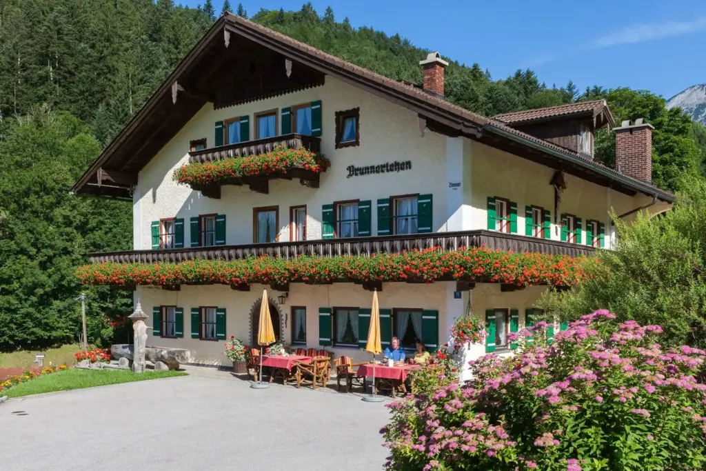 Sonnenterrasse vor dem Gästehaus Brunnerlehen mit Frühstückstischen