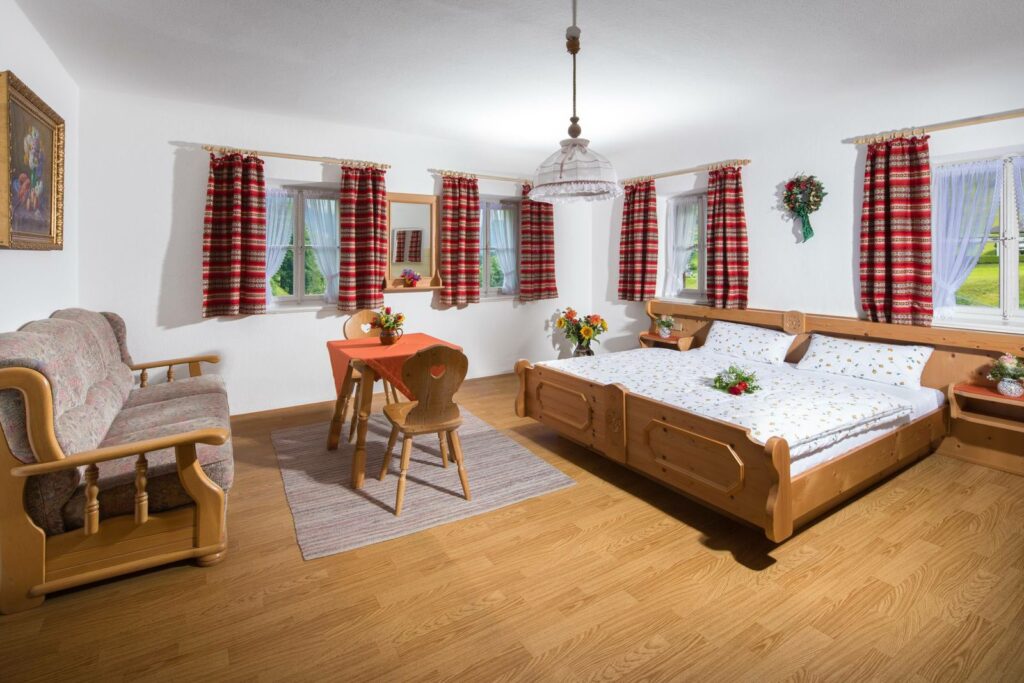 Familienzimmer im Gästehaus Brunnerlehen mit Sitzecke und Doppelbett